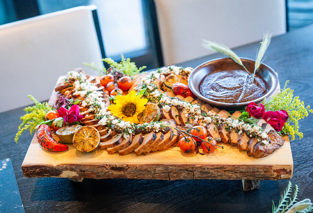 fine dining sliced pork served with blistered peppers and tomatoes