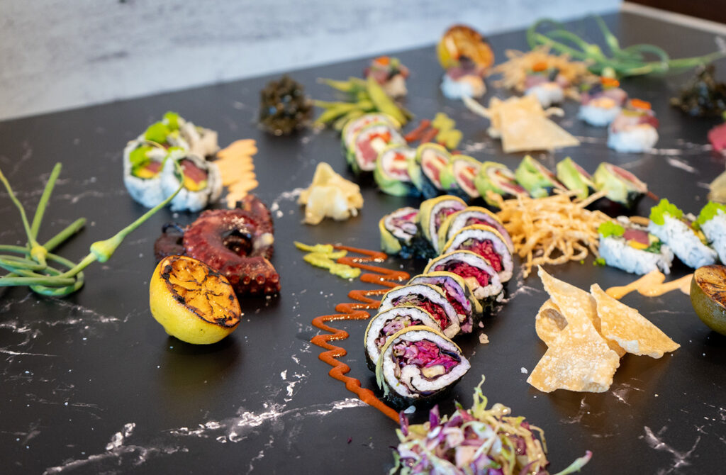 marble counter top with sushi and assorted accompaniments